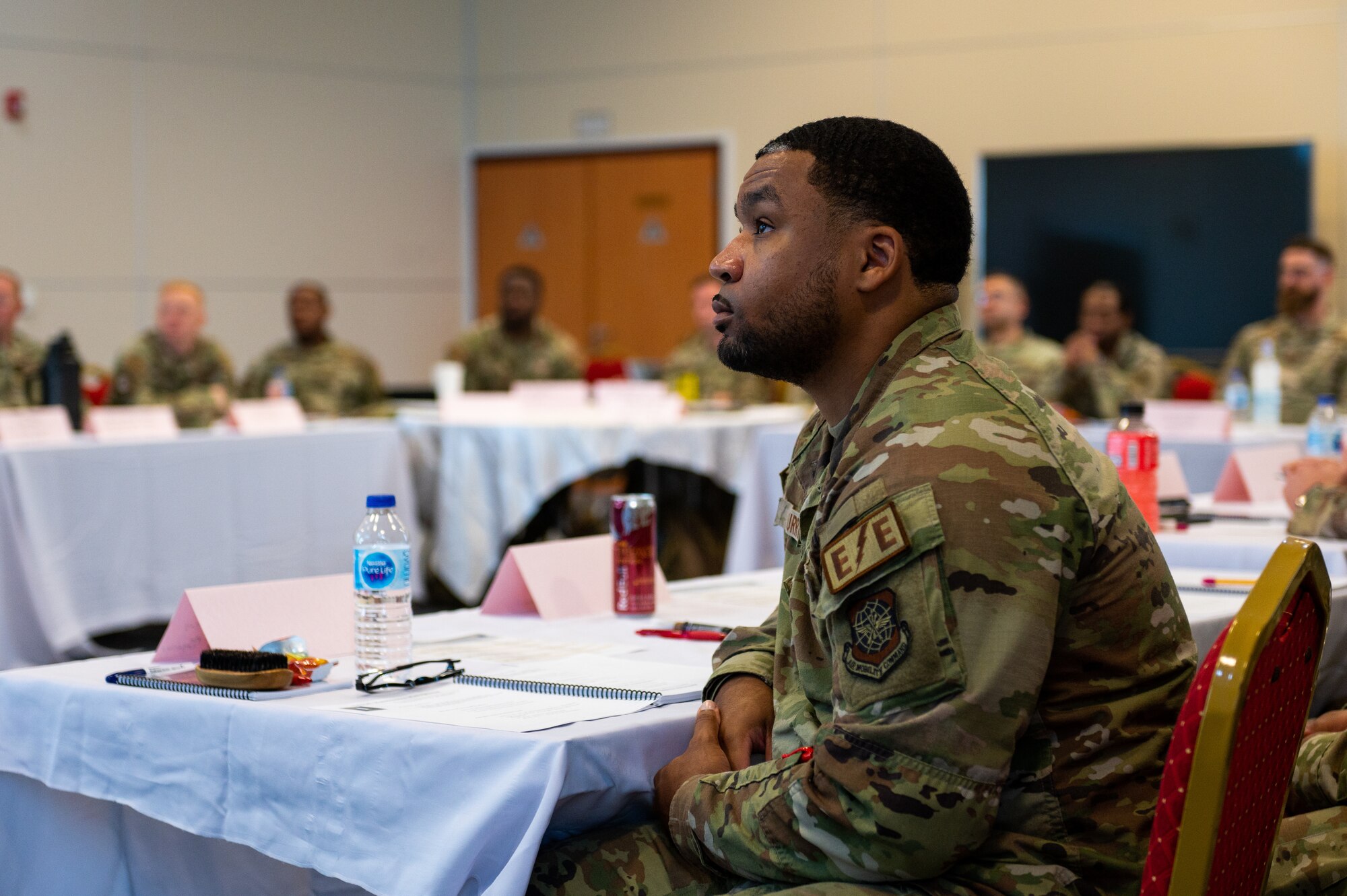 An Airmen listens intently to a speaker out of frame