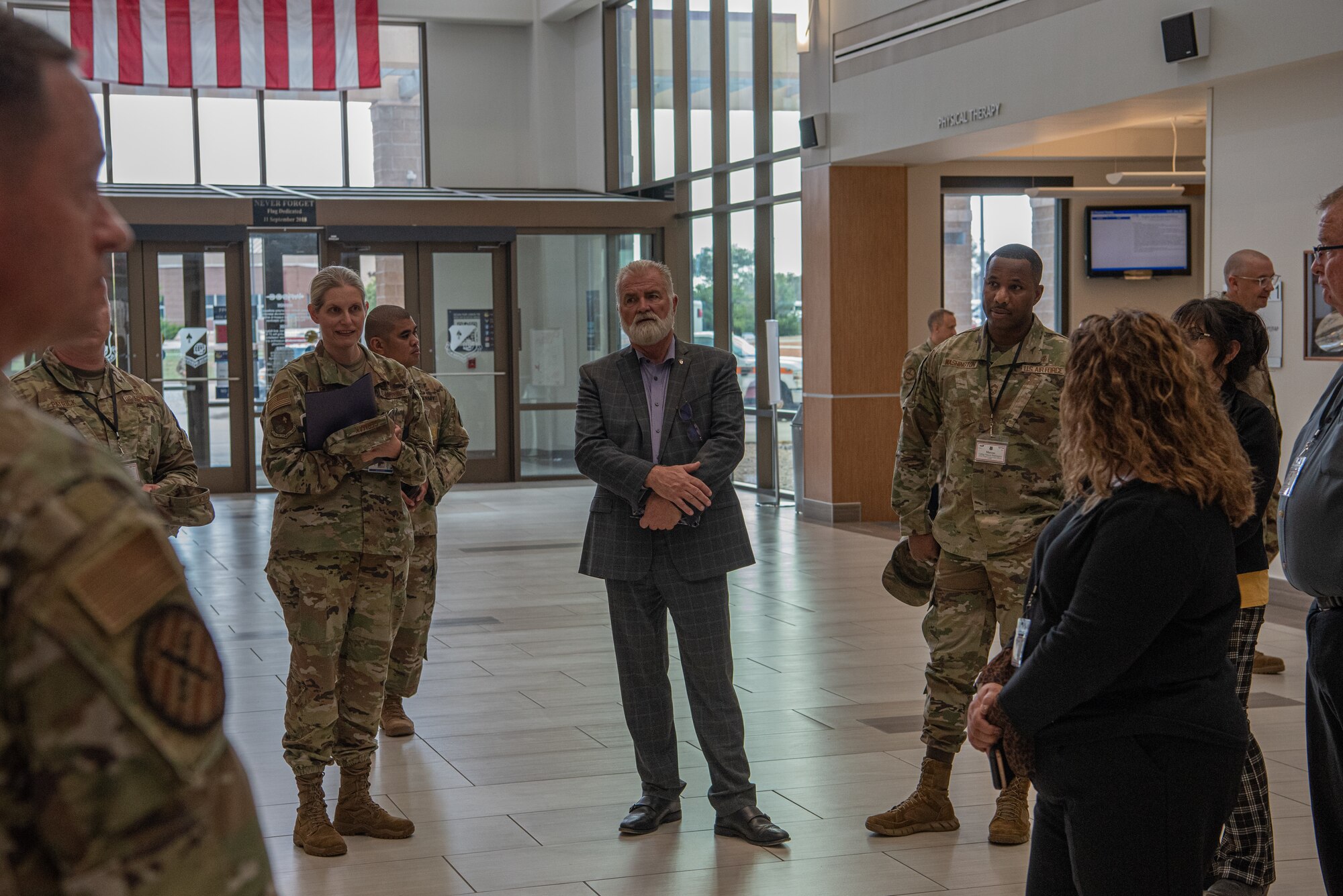 A group of service members stand in the atrium of a Medical Group