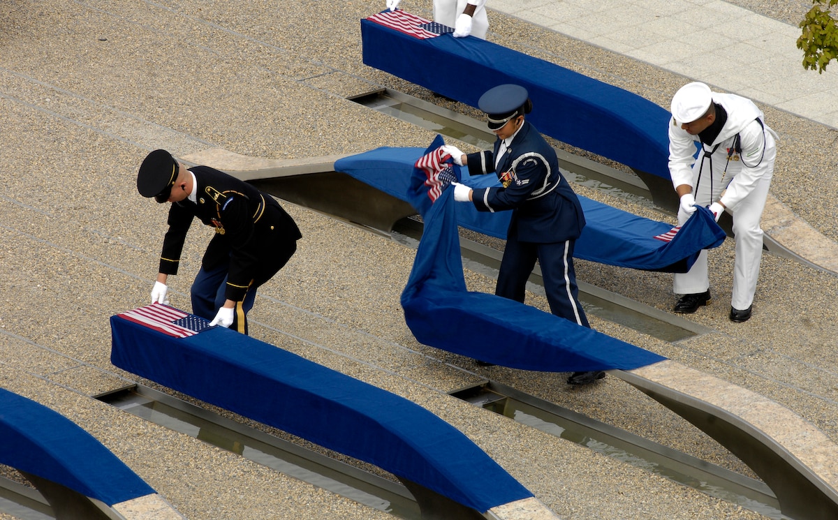 Soldiers from various Services remove the coverings to reveal the Pentagon Memorial tributes.