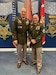 Two men U.S. Army uniforms pose for a photo.