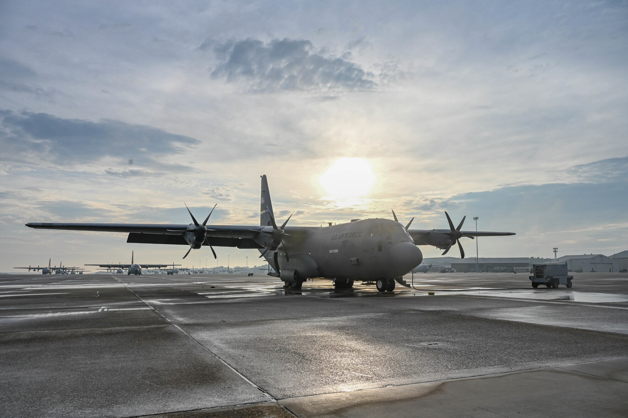 A C-130 is parked on a flightline.