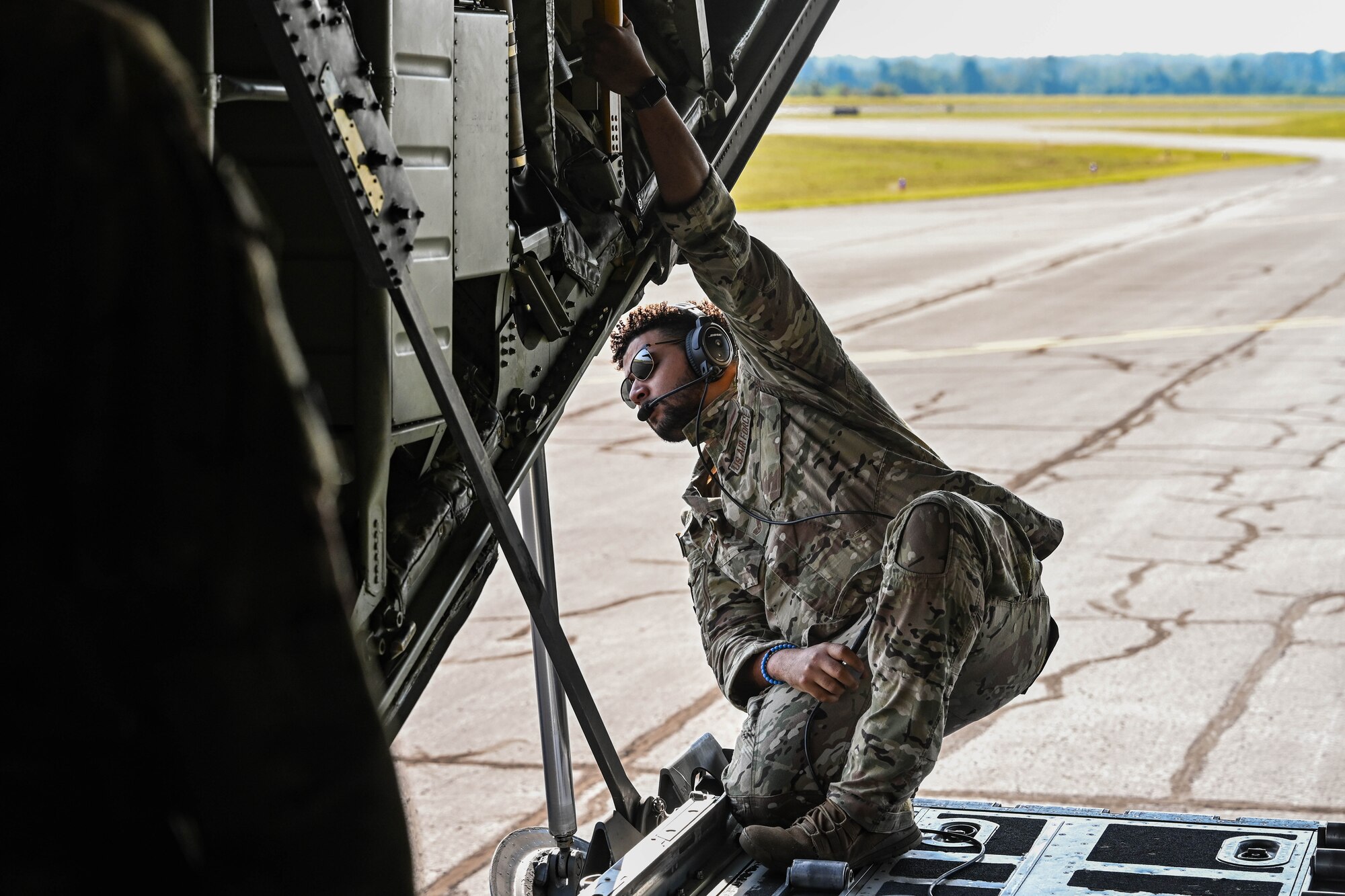 An Airman looks out the back of an aircraft.