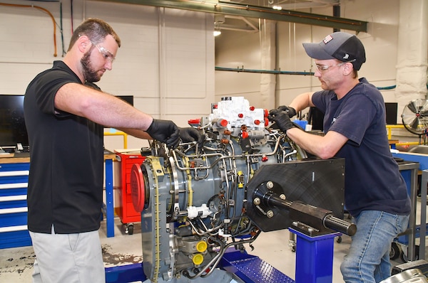 Steven Murray, left, and Dakota Martin, aircraft engine mechanics at Fleet Readiness Center East (FRCE, begin disassembly of a lift fan clutch for the F-35B Lightning II aircraft. FRCE personnel became the first within the Department of Defense (DoD) to perform a successful assembly of this component outside of Rolls Royce’s LiftWorks facility in Indianapolis. (Photo by Joe Andes, Fleet Readiness Center East Public Affairs)