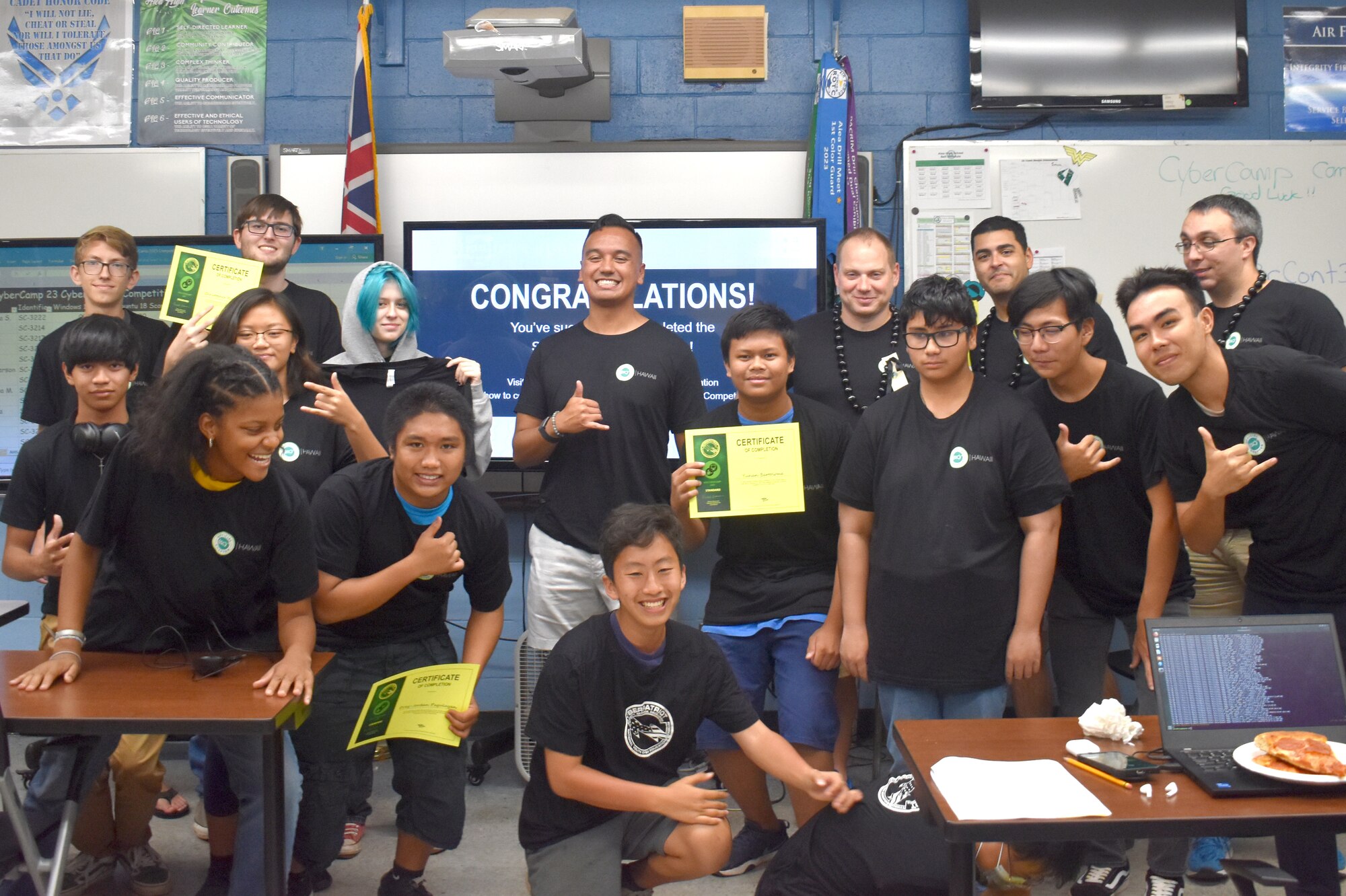 Student pose for a photo with their instructors, after recently graduating from Air Force Association Cyber Camp, at Aiea High School, Hawaii, June 9, 2023.