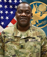 Male Soldier posed in front of two flags