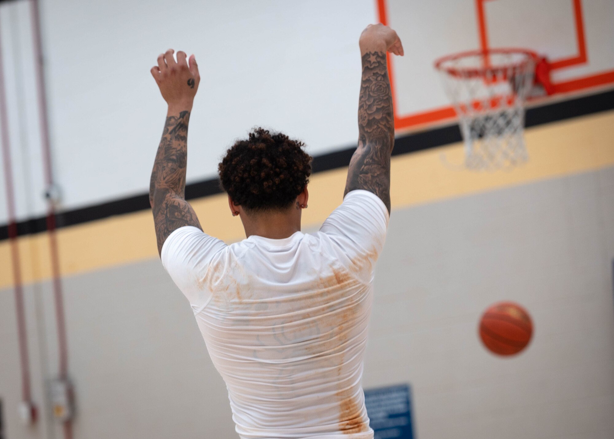 A man shoots a basketball into a hoop.