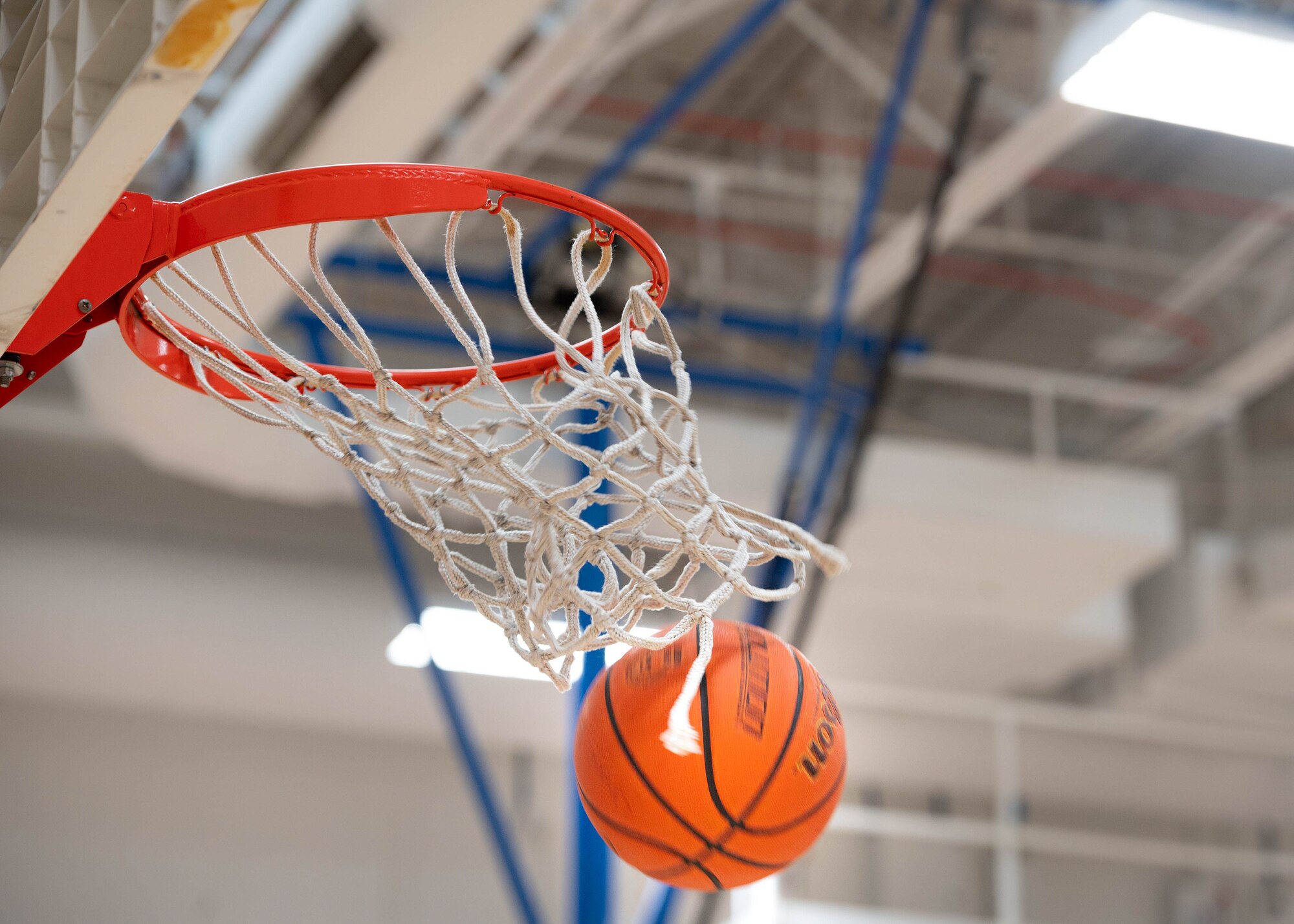 A basketball falls through a hoop.