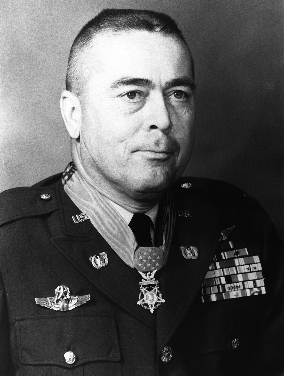 A person in uniform who wears a medal on his neck poses for a photo.