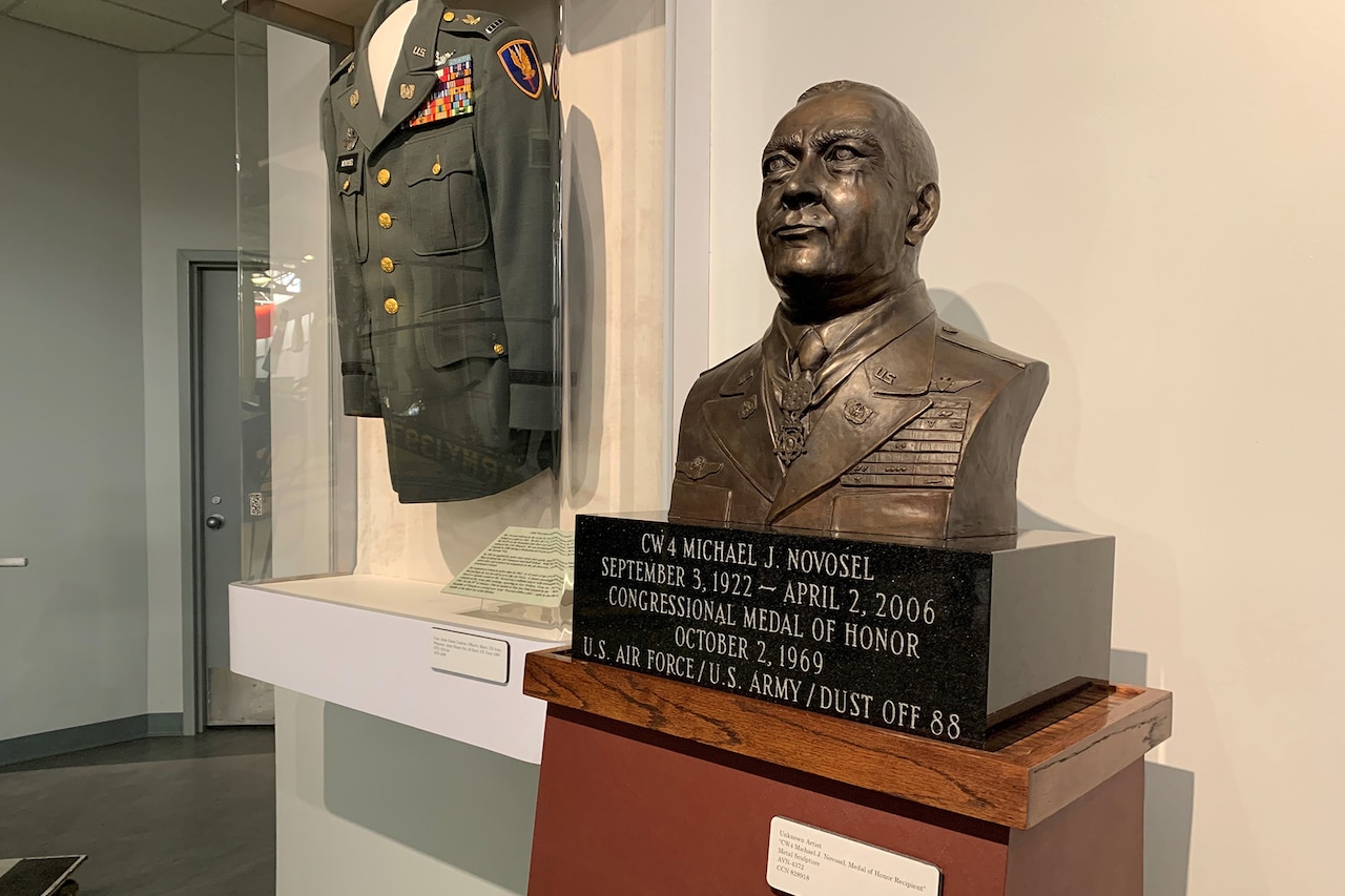 A bronze bust and a military uniform are displayed.