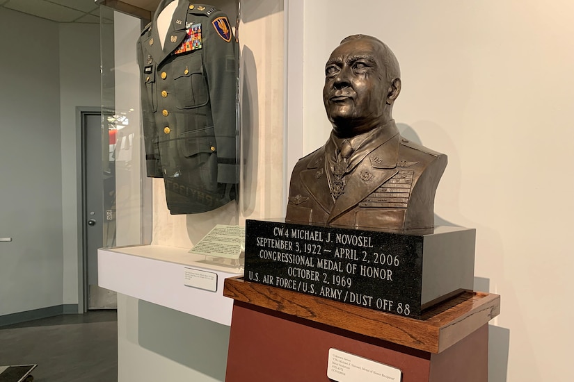 A bronze bust and a military uniform are displayed.