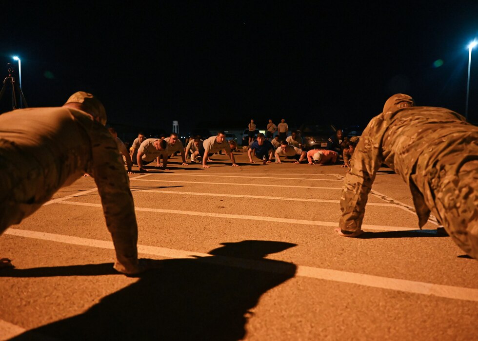 Members of the 17th Training Wing do push-ups before the Jacobson Memorial Ruck at Goodfellow Air Force Base, Texas, Sept. 28, 2023. Seventeen push-ups were performed by the participants in remembrance of fallen defenders. (U.S. Air Force photo by Senior Airman Sarah Williams)