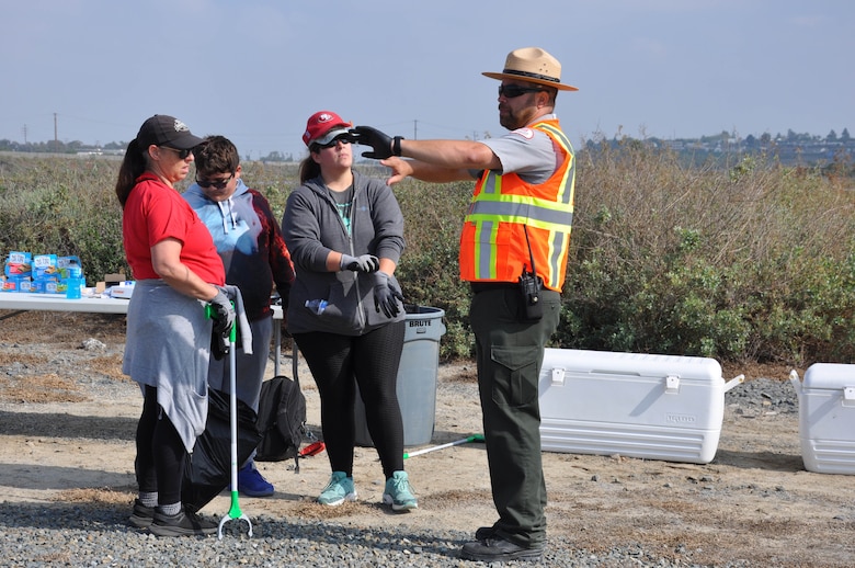 U.S. Army Corps of Engineers Los Angeles District park ranger Nick Figueroa indicates the boundries for volunteers at the cleanup of the Santa Ana River Marsh, Sept. 23, in Newport Beach, Calif.