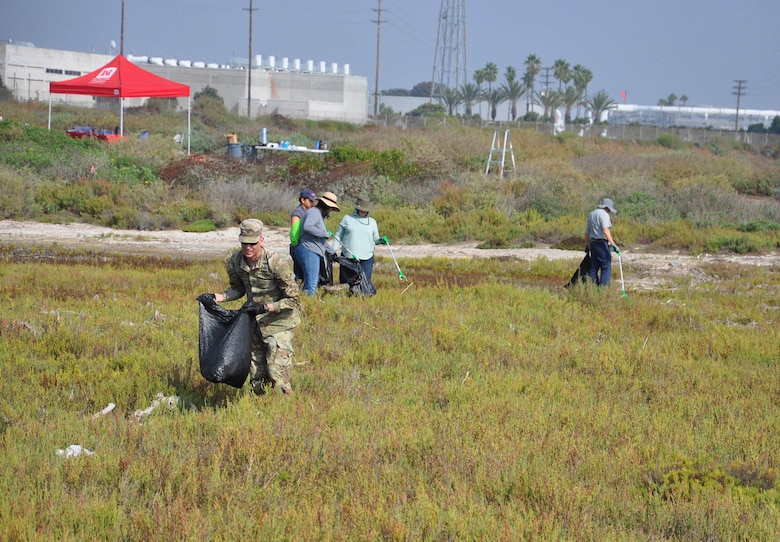 District commander Col. Andrew Baker picks up trash with scouts and adult leaders of Boy Scout Troop 93 Fullerton, Sept. 23, in Newport Beach, Calif.
