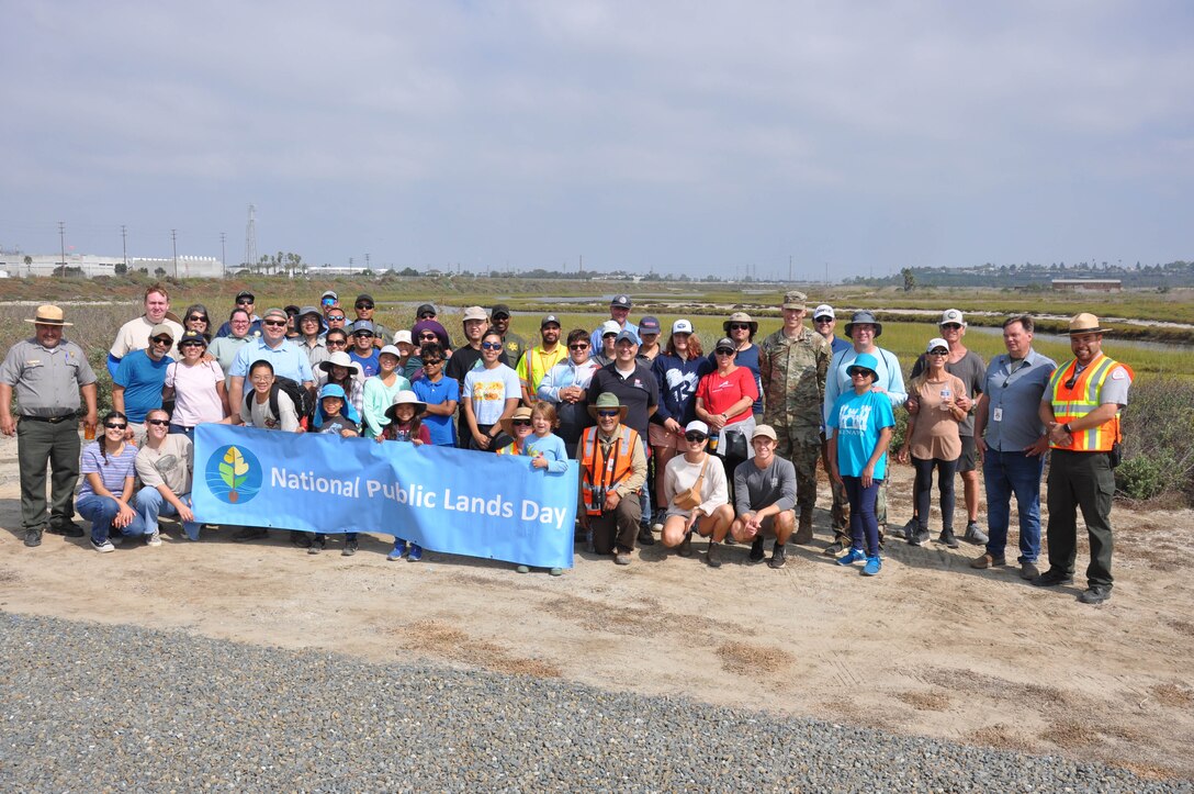 Civilian and U.S. Army Corps of Engineers volunteers pose for a photo at the conclusion of a cleanup of the Santa Ana River Marsh, Sept. 23, in Newport Beach, Calif.