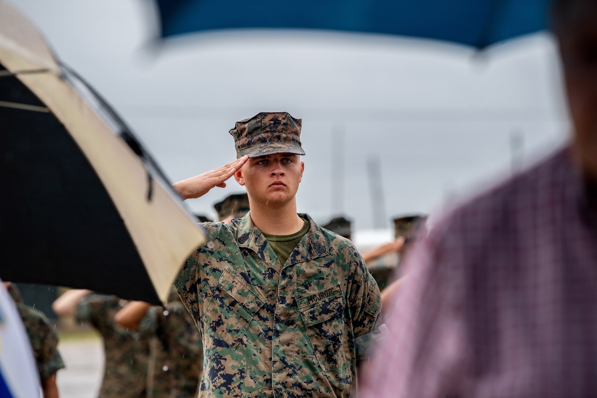 A Junior Reserve Training Officer Corps Marine Corps cadet holds a salute during taps at Spence Field in Moultrie, Georgia, Sept. 26, 2023. The JROTC cadets guided traffic and rendered honors during the ceremony. (U.S. Air Force photo by Senior Airman Courtney Sebastianelli)