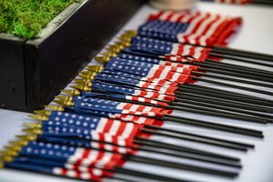 Sixty-two flags lie on a table during a memorial ceremony at Spence Field in Moultrie, Georgia, Sept. 26, 2023.  During the ceremony, the names of the 62 Airmen were read and honored with a 48-star American flag. Courtney Sebastianelli)