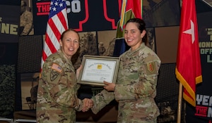 U.S. Army Brig. Gen. Niave F. Knell, the 1st Infantry Division deputy commanding general of support, awards a Certificate of Appreciation to 2nd Lt.Sarah Sullivan, a Soldier assigned to 2nd Battalion, 34th Armor Regiment, 1st Armored Brigade Combat Team, 1st Inf. Div., for her efforts in helping the Army Emergency Relief program at Victory Hall on Fort Riley, Kansas, Sep. 6, 2023. Sullivan helped raise money for the program that will then be used to help other Soldiers in need. (U.S. Army photo by Spc. Mackenzie Striker)