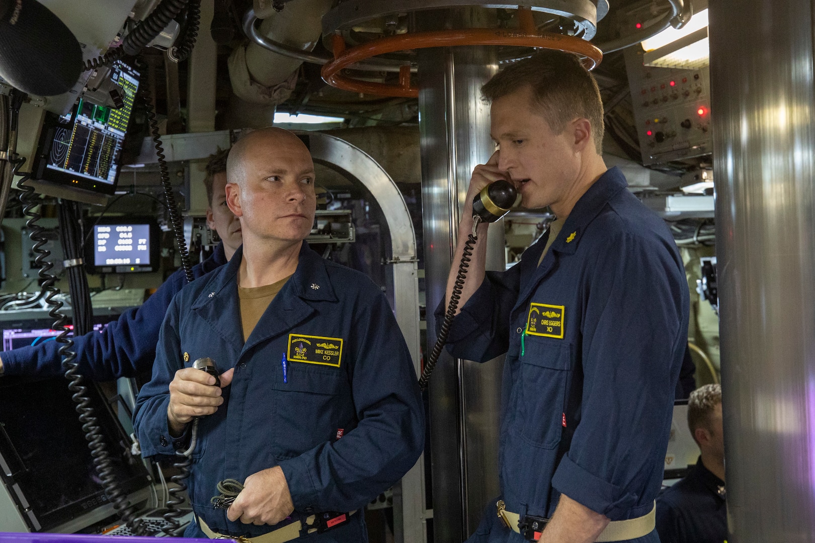 Photo depicts crew of Ohio-class ballistic missile submarine USS Louisiana (SSBN 743) during Demonstration and Shakedown Operation-32 (DASO-32) demonstrating launching procedures for visitors aboard the submarine. Two crew members stand side by side using communications tools.