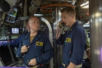 Photo depicts crew of Ohio-class ballistic missile submarine USS Louisiana (SSBN 743) during Demonstration and Shakedown Operation-32 (DASO-32) demonstrating launching procedures for visitors aboard the submarine. Two crew members stand side by side using communications tools.