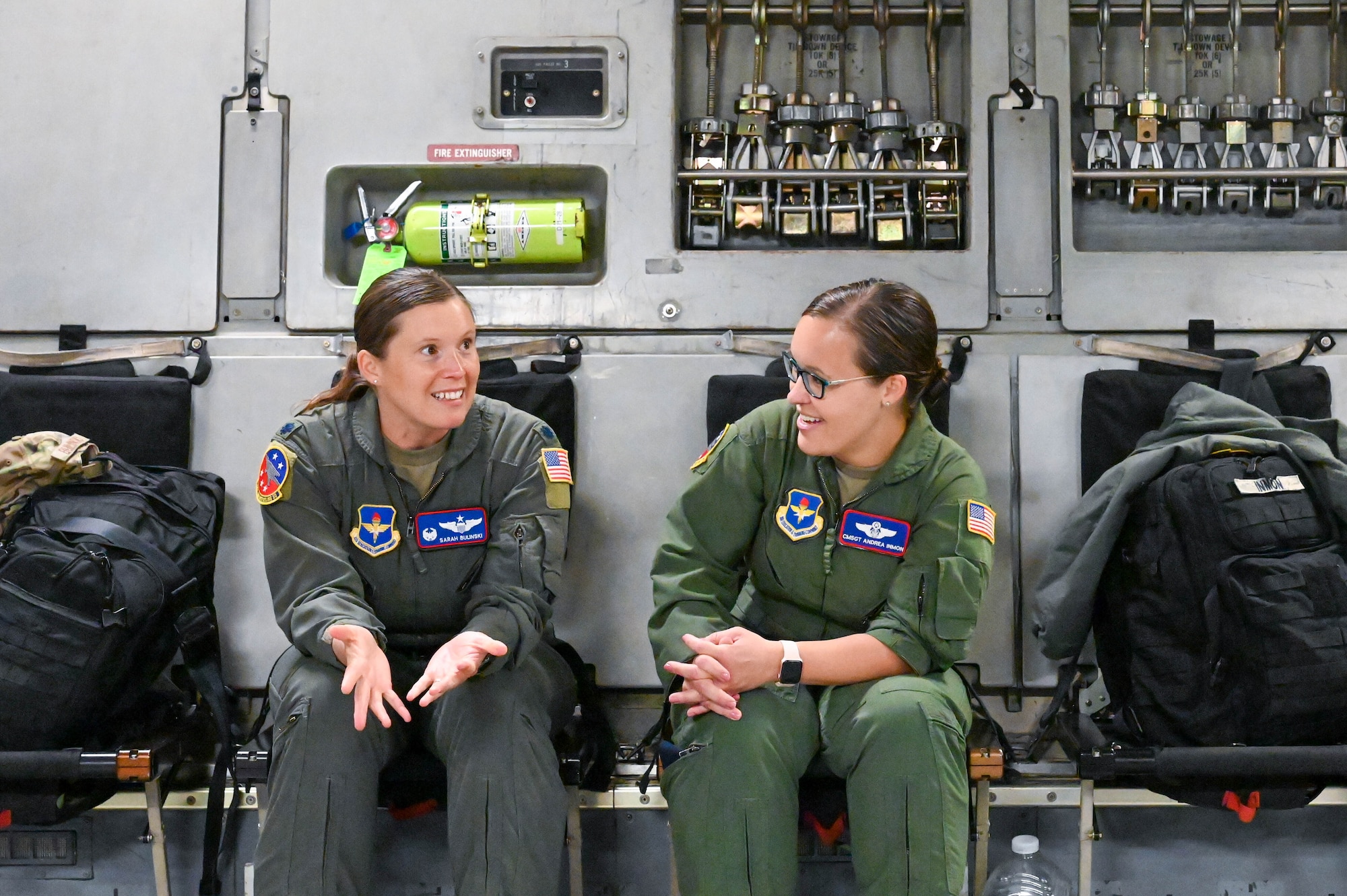 U.S. Air Force Lt. Col. Sarah Brilinski, left, 54th Air Refueling Squadron (ARS) commander, speaks to Chief Master Sgt. Andrea Inmon, right, 54th ARS senior enlisted leader, during a flight from Altus Air Force Base (AFB), Oklahoma, to attend the Torch Athena Rally in San Antonio, Texas, Sept. 19, 2023. The Aircrew from Altus AFB attended the event to showcase static displays of a KC-135 Stratotanker, KC-46 Pegasus and a C-17 Globemaster III. (U.S. Air Force photo by Airman 1st Class Heidi Bucins)