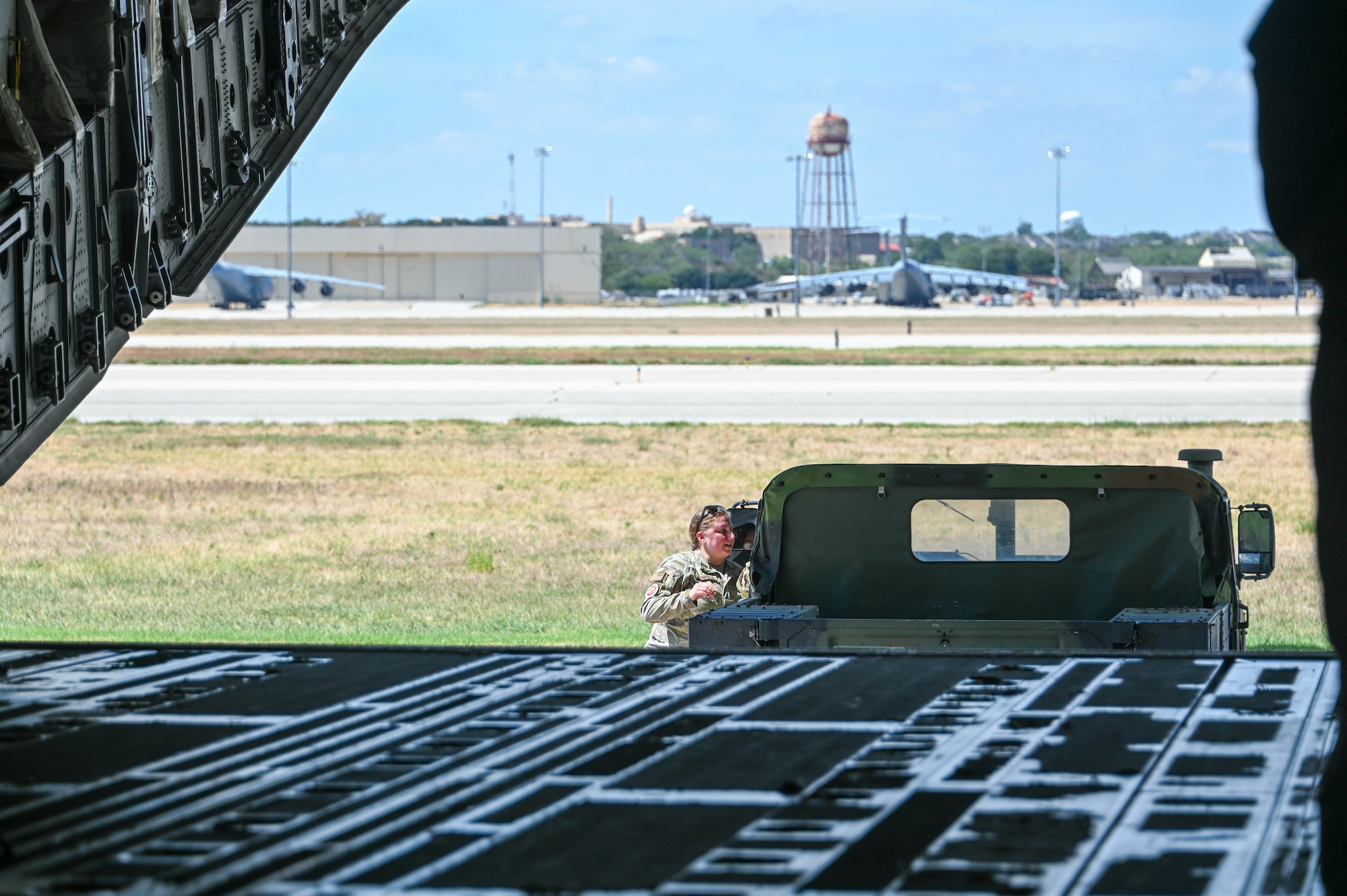 U.S. Air Force Staff Sgt. Jackie Mermolia, 58th Airlift Squadron loadmaster instructor, assists with a vehicle download from a C-17 Globemaster III at the Torch Athena Fly-In in San Antonio, Texas, Sept. 21, 2023. The fly-in event focused on empowerment through engagement and increasing diversity in aviation career trajectories. (U.S. Air Force photo by Airman 1st Class Heidi Bucins)
