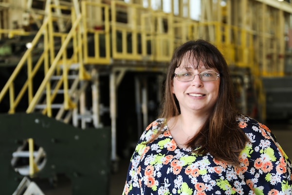 Jessica Walden, Industrial Engineer, Marine Depot Maintenance Command stands in front of the craneway at Production Plant Albany, Marine Corps Logistics Base Albany, Ga. Walden has recently completed work on the Joint Light Tactical Vehicle Proof of Principle and briefed findings from that effort to the Federal Improvement Team.