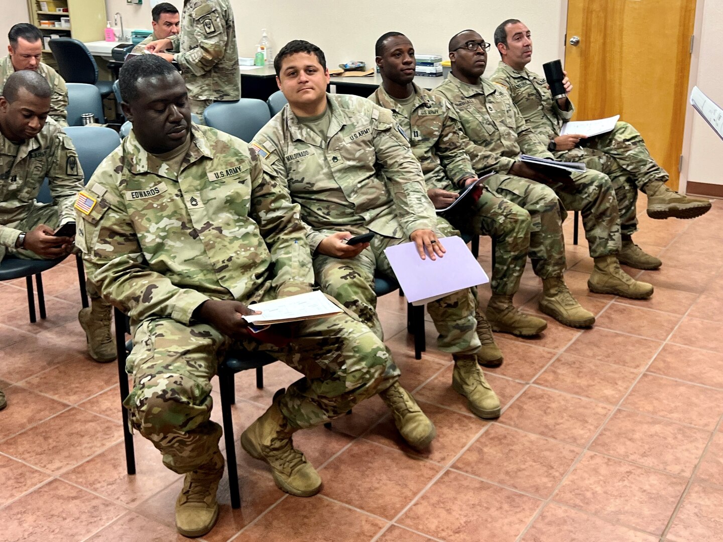 Group of Soldiers sitting in a hospital waiting room.
