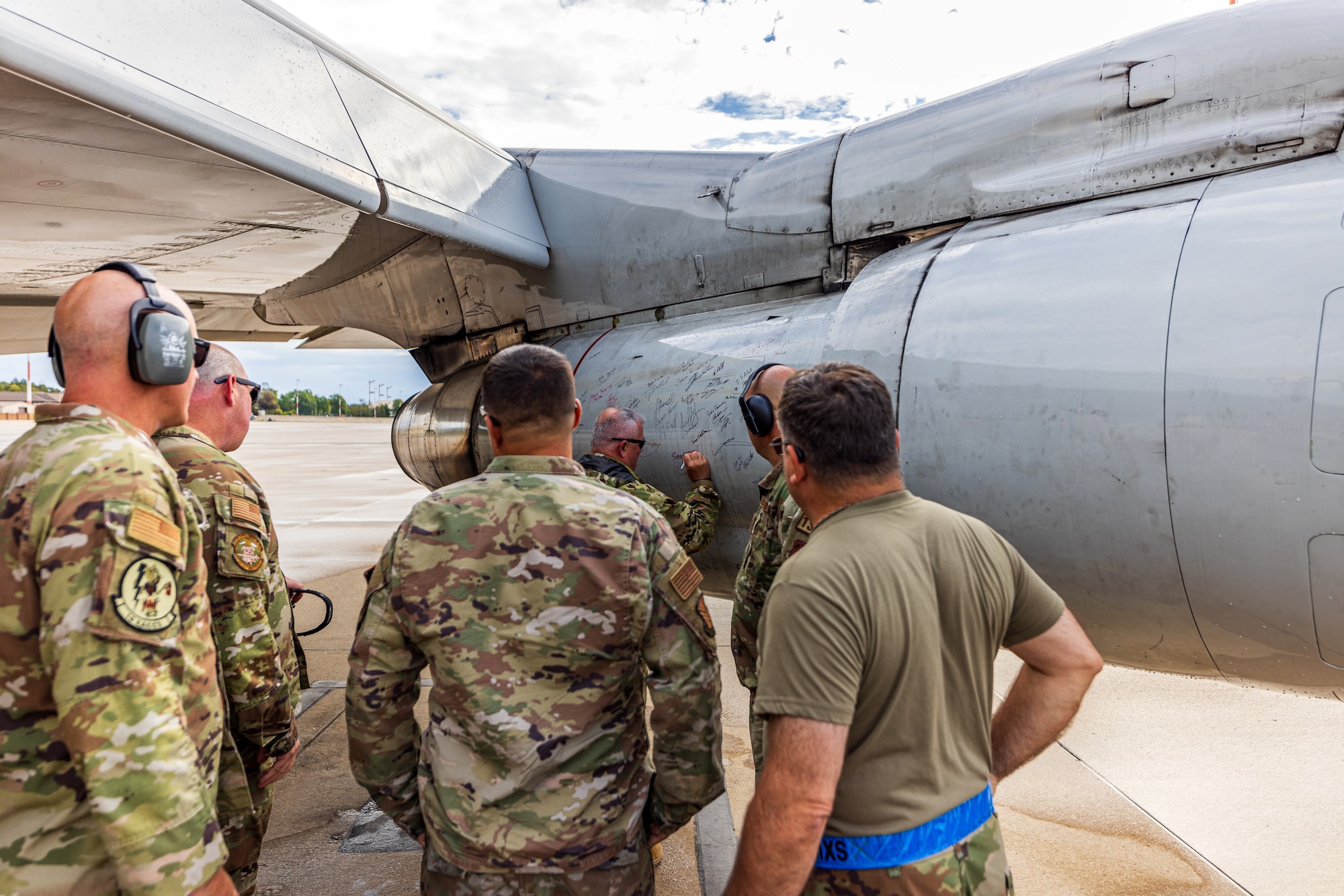 U.S. Airmen with the 116th Air Control Wing, Georgia Air National Guard, sign an engine of an E-8C Joint STARS for its last mission at Ramstein Air Force Base,  Germany, Sept. 21, 2023.