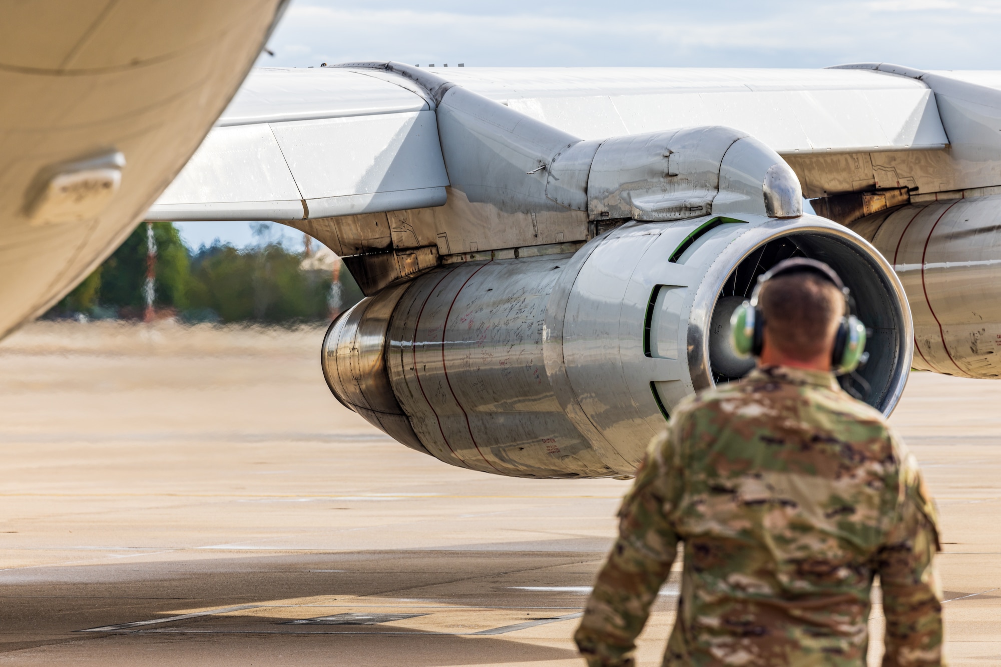 U.S. Airmen with the 116th Air Control Wing, Georgia Air National Guard, sign an engine of an E-8C Joint STARS for its last mission at Ramstein Air Force Base,  Germany, Sept. 21, 2023.