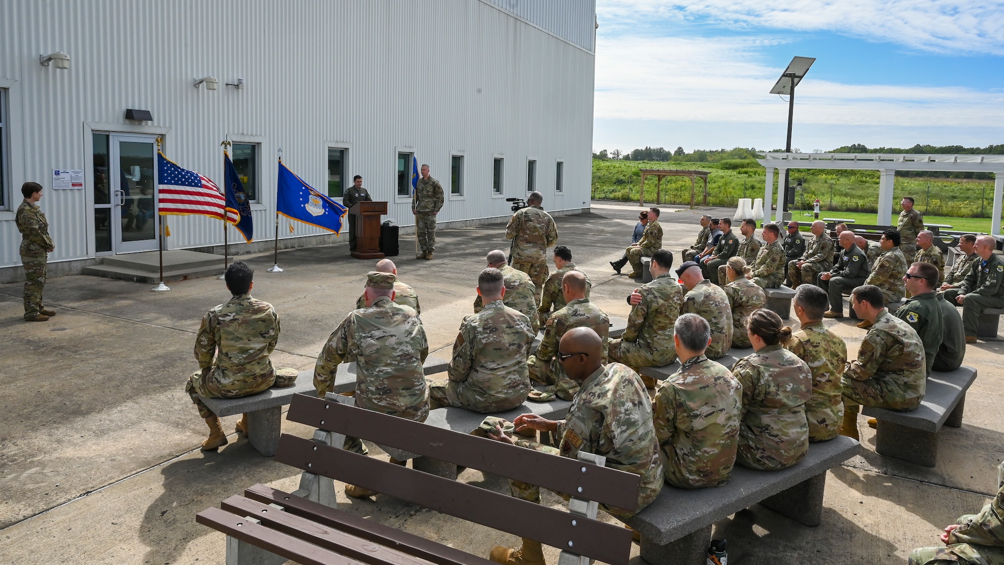 A group of troops are sitting outside.