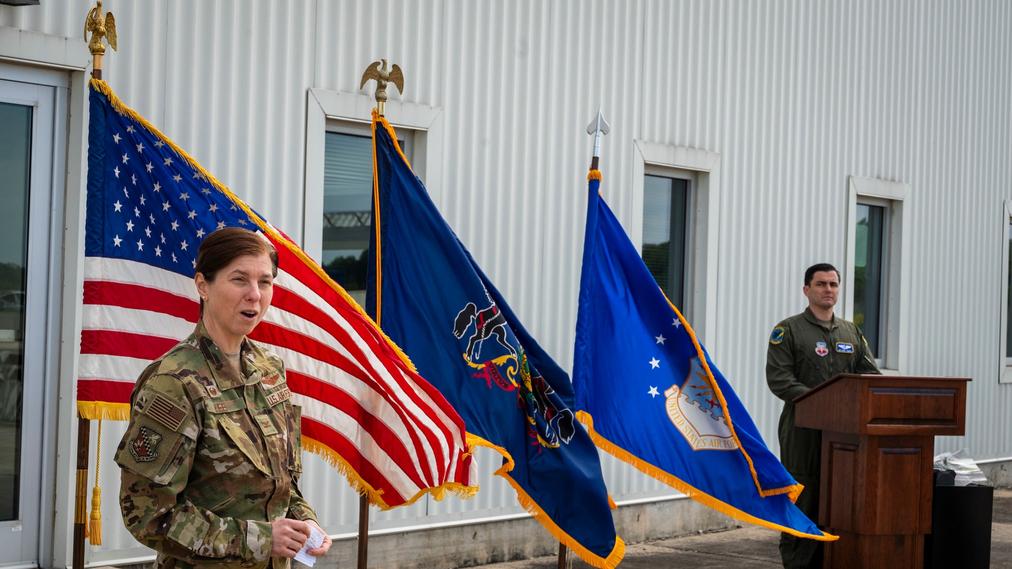 A  female colonel in USAF uniform speaks during a change of command ceremony.