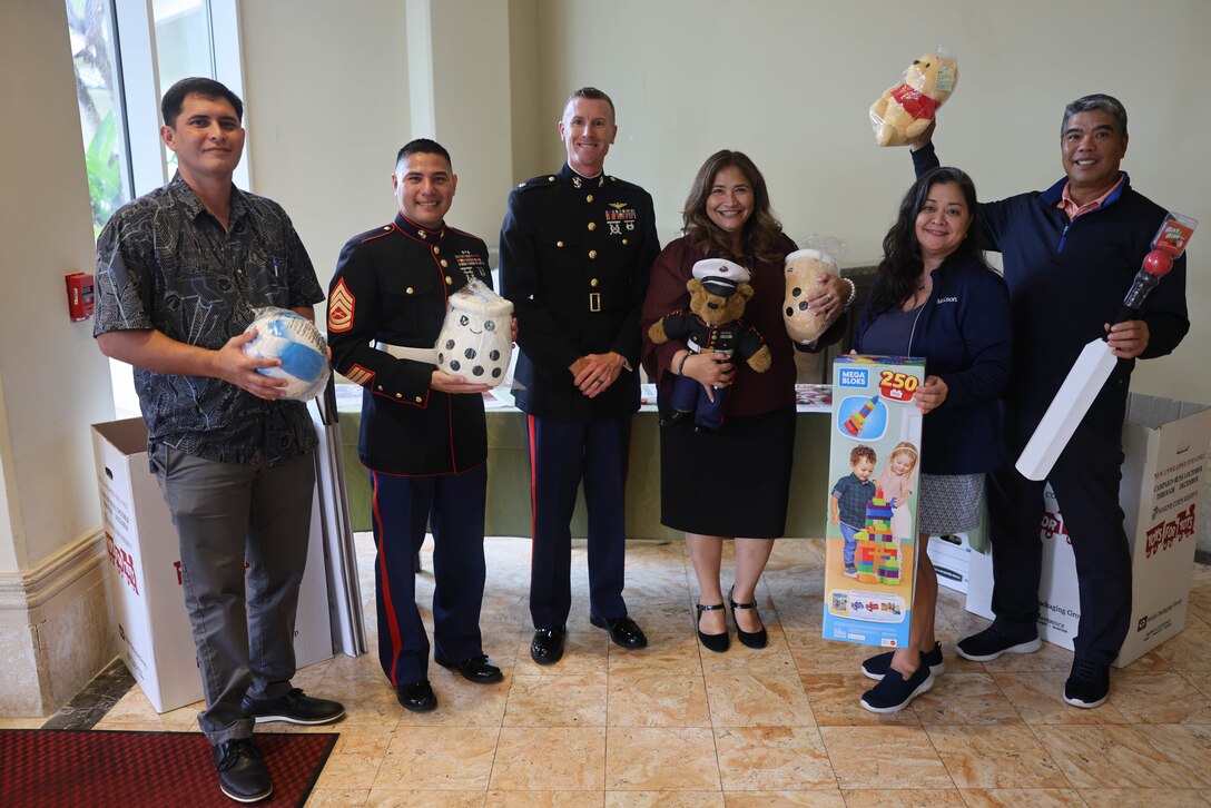 Members of the Guam Chamber of Commerce, Matson, and U.S. Marines with Marine Corps Base Camp Blaz pose for a photo for the commencement of the 14th annual Toys for Tots campaign at the Hilton Hotel, Guam, Sept. 27, 2023. Marines from MCB Camp Blaz will deliver toy collection boxes to sites across Guam during the first week of October. Toy collection will conclude during the week of Dec. 4. Last year 6,848 toys were collected on Guam, going to children in need and spreading a message of happiness and hope during the holiday season. At the conclusion of the campaign, a total of 11,075 toys were distributed throughout the islands of Guam, Saipan, Tinian, and Rota. (U.S. Marine Corps photo by Lance Cpl. Garrett Gillespie)