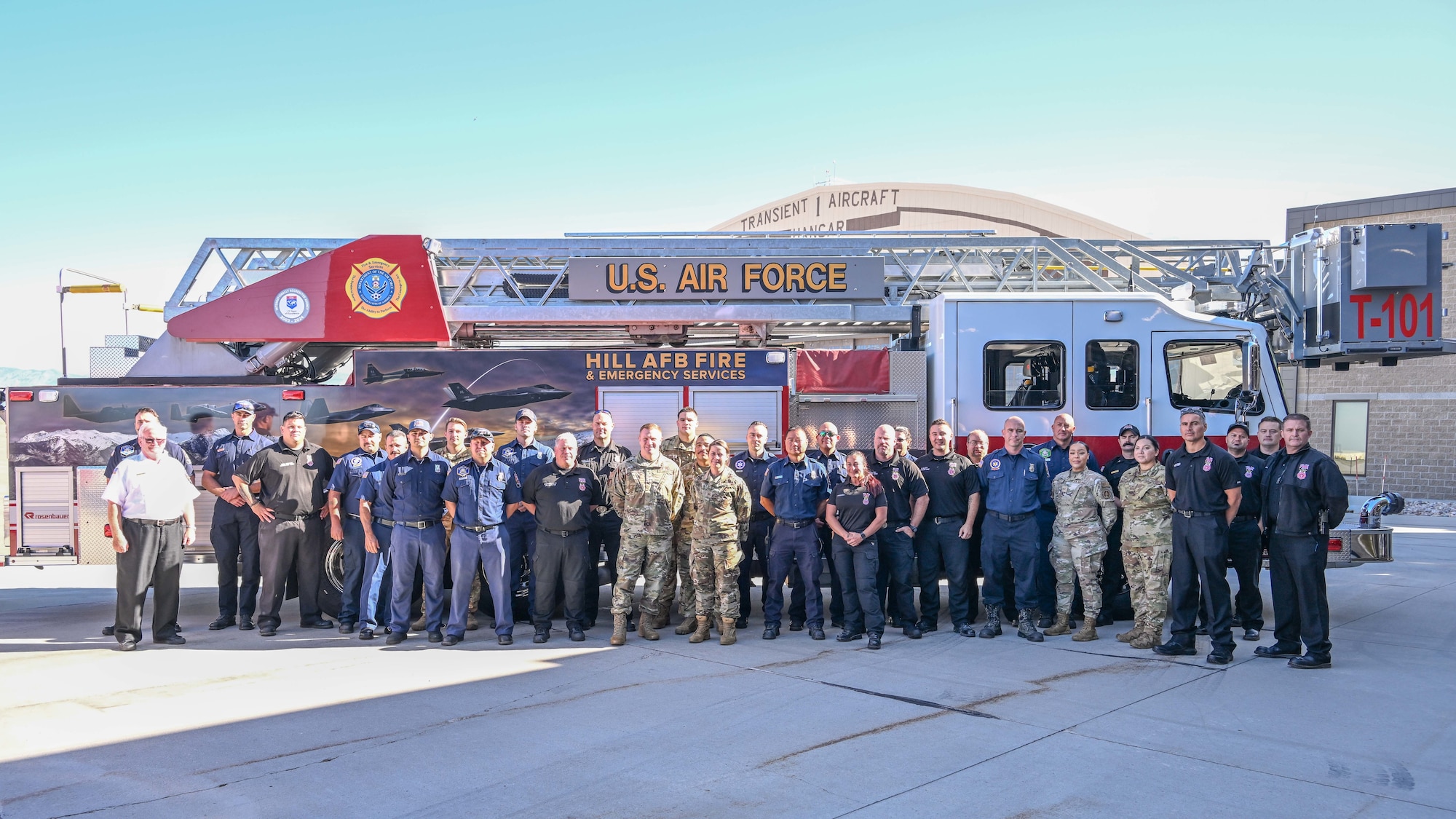 Firefighters from the 775th Civil Engineering Group pose with (center) Col. Jeffrey Holland, 75th Air Base Wing commander and Col. Meghan M. Szwarc, 75th ABW deputy commander, after signing the Fire Prevention Week proclamation