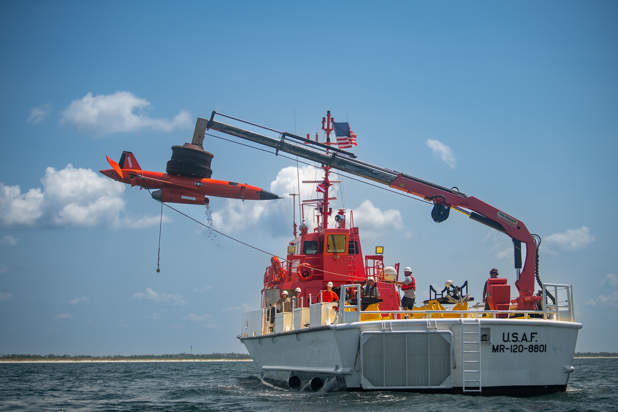 a boat crane lifts an aerial target out of the water