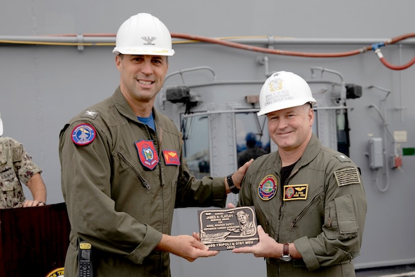 Rear Adm. Randall W. Peck, right, presents the 2022 Admiral James H. Flatley Memorial Award to Capt. John Kiefaber, commanding officer of USS Tripoli (LHA 7).