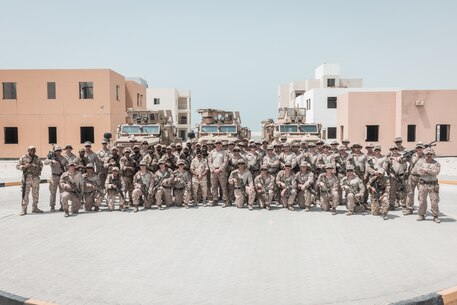 U.S. Marines with Battalion Landing Team 1/6, 26th Marine Expeditionary Unit (Special Operations Capable) (26MEU(SOC)) and Royal Bahrain Marines pose for a group photo after completing an urban terrain force-on-force training event during a Bahrain bilateral training exercise, undisclosed location in the Middle East, Sept. 10, 2023. The training was completed alongside members of the Royal Bahrain Marine Force to facilitate the exchange of tactics, techniques and procedures between partners. Components of the Bataan Amphibious Ready Group and 26MEU(SOC) are deployed to the U.S. 5th Fleet area of operations to increase maritime security and stability in the Middle East region. (U.S. Marine Corps photo by Cpl. Kyle Jia)