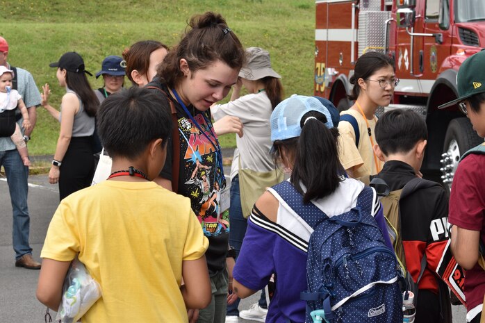 Lance Corporal Emmaline Della Maggiora talks with children about their experience visiting the installation fire station.