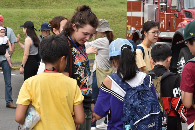 Lance Corporal Emmaline Della Maggiora talks with children about their experience visiting the installation fire station.