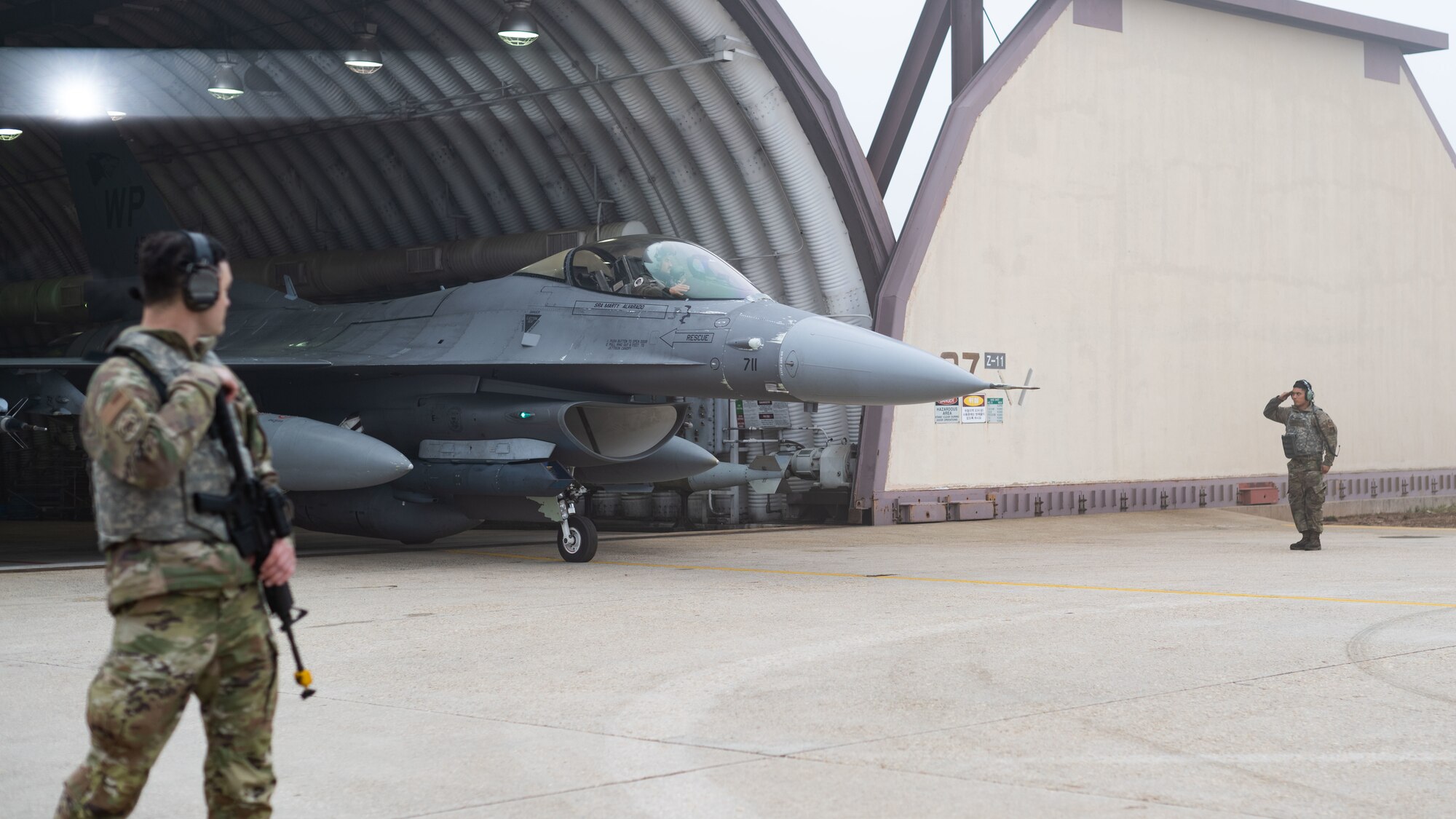 Airman 1st Class Juan Mendoza salutes Maj. Rex Anderson during an F-16 Fighting Falcon launch.