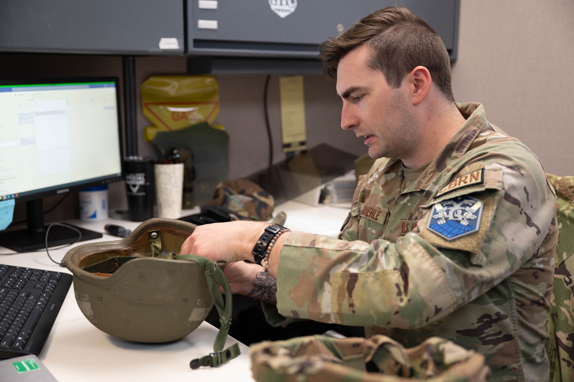 Senior Airman Ruehle is fixing a mid-cut kevlar helmet.