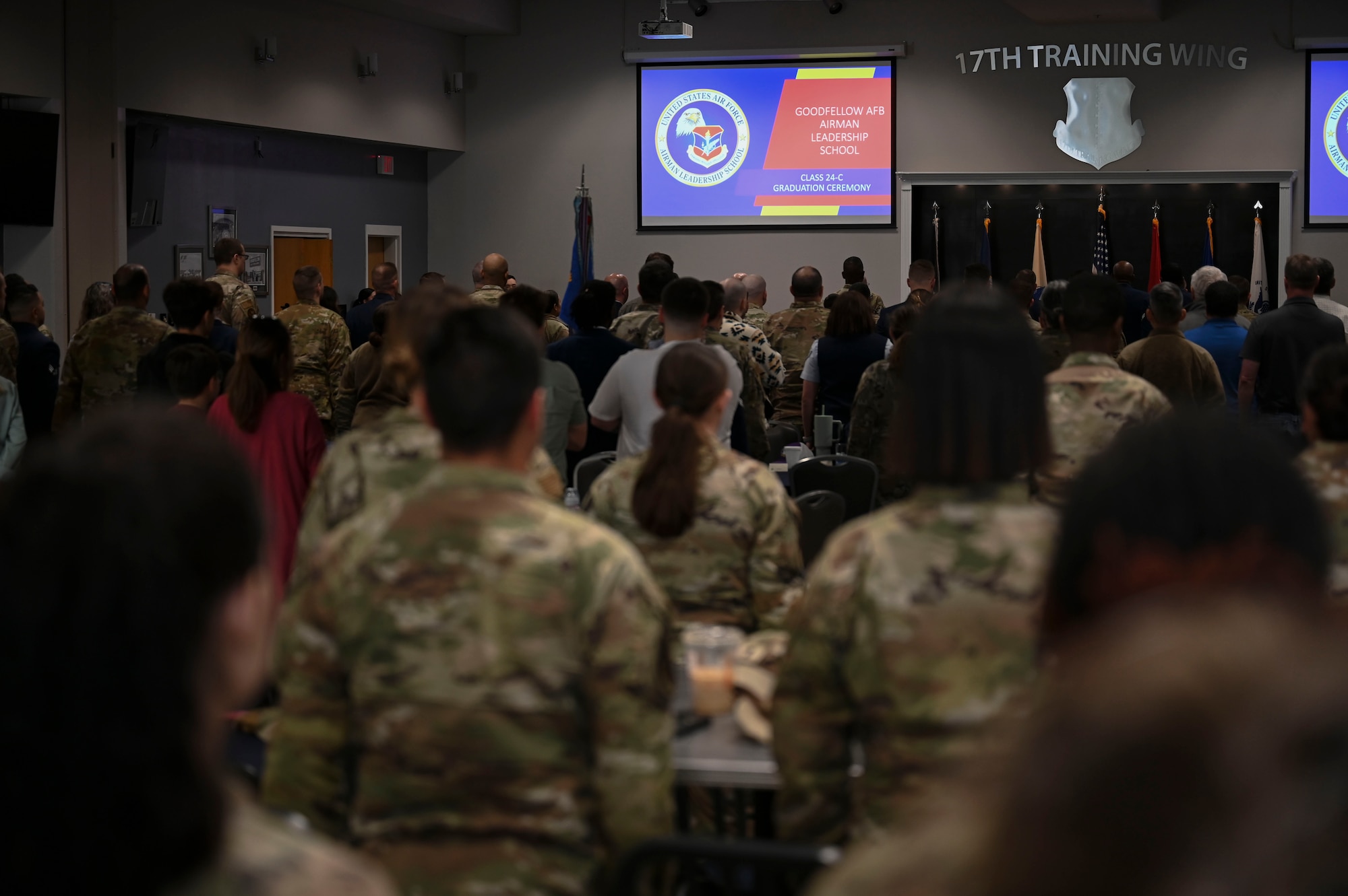 Airmen and Goodfellow personnel attending the Airmen Leadership School Class 24-C graduation stand for the national anthem at the Powell Event Center, Goodfellow Air Force Base, March 29, 2024. “The Star-Spangled Banner” is played at the beginning of most military events. (U.S. Air Force photo by Airman 1st Class Madison Collier)