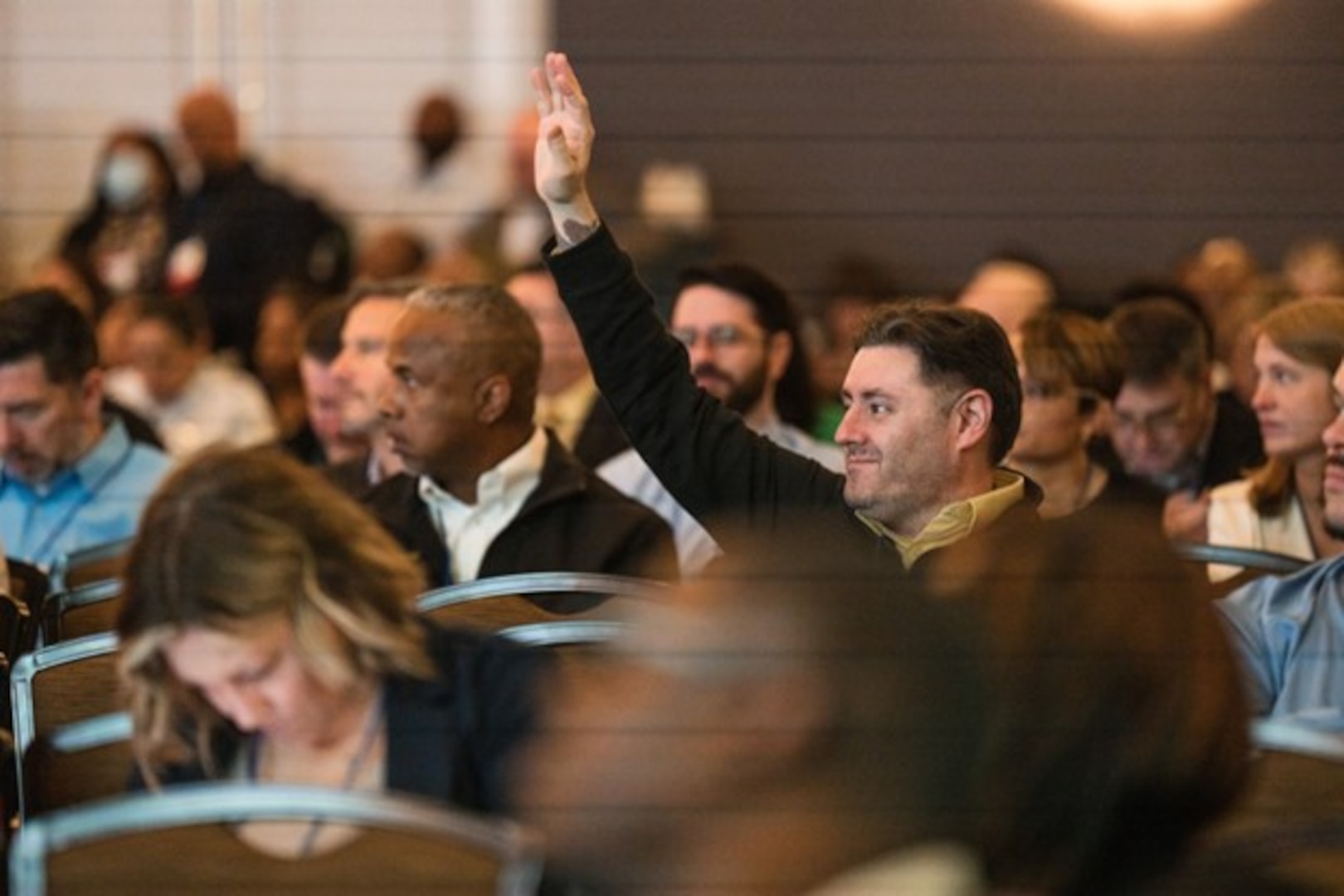 Audience member at GovTravels raising hand with a question during GovTravels 2024 session.