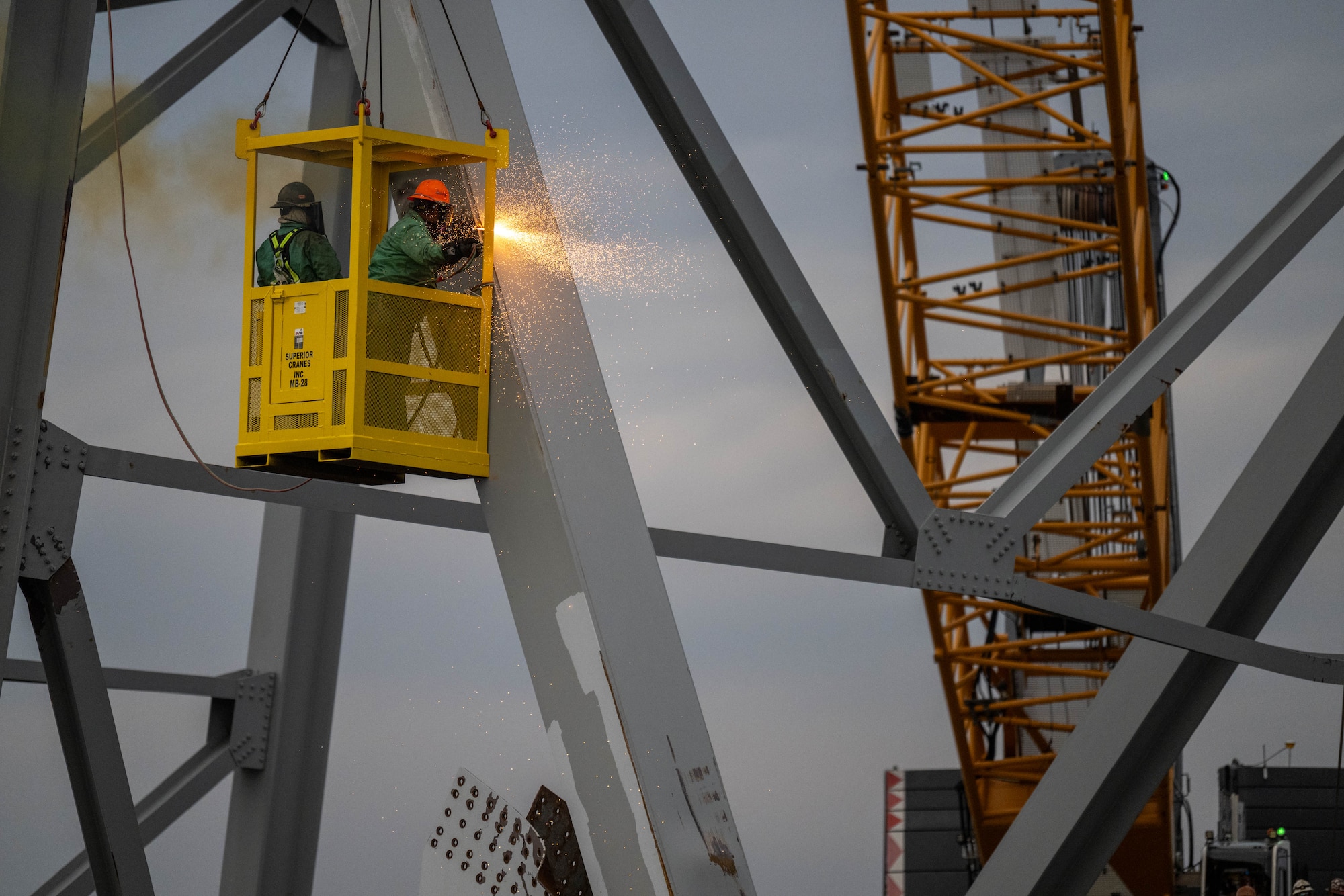 Demolition crews with the Unified Command begin cutting the top portion of the north side of the collapsed bridge into smaller sections for safe removal by crane in the Patapsco River, in Baltimore, Maryland, March 30, 2024. Salvage teams use exothermic cutting torch to systematically separate sections of the steel bridge, which will be taken to a disposal site. (U.S. Coast Guard photo by Petty Officer 2nd Class Taylor Bacon)