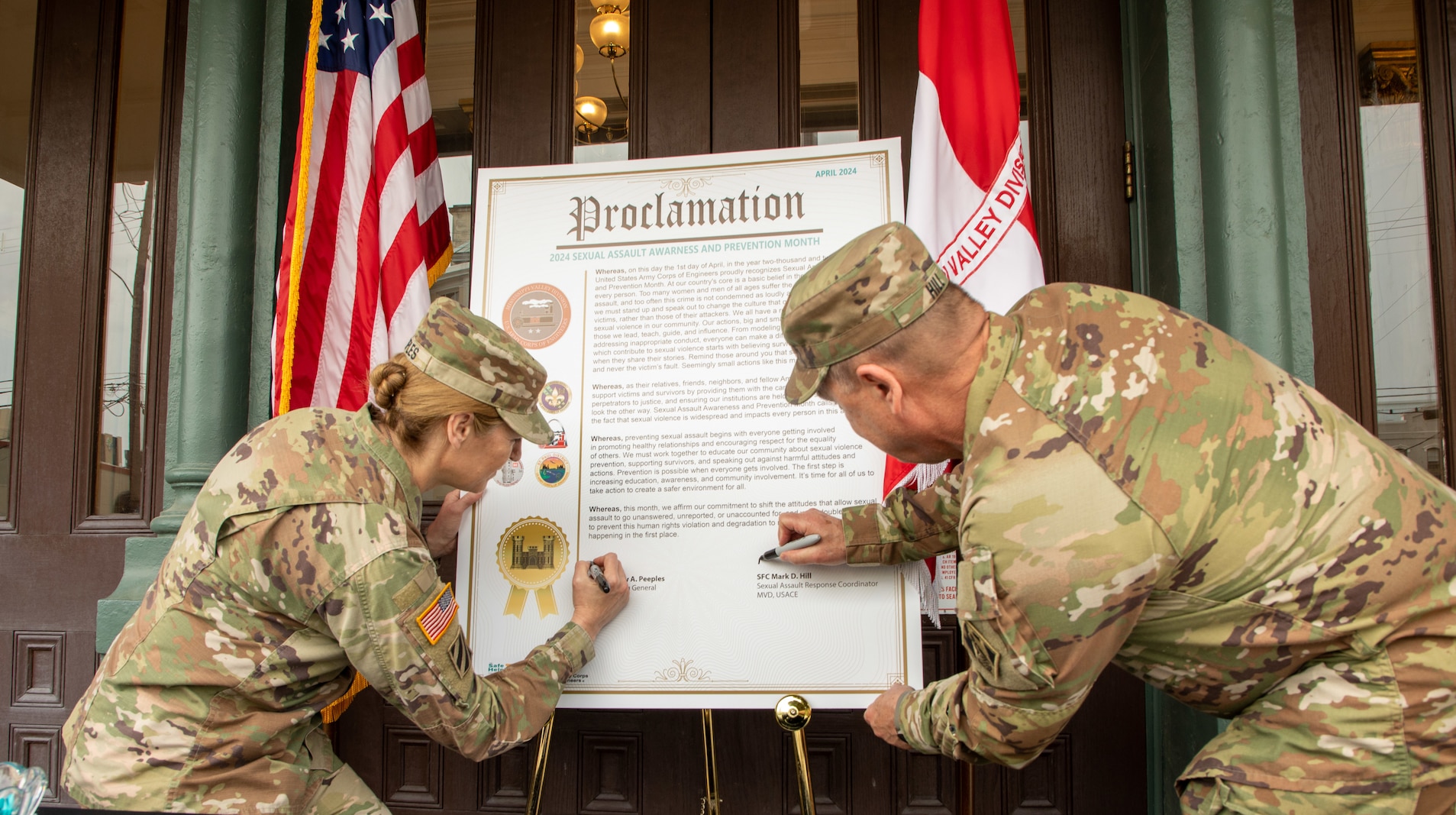 Uniformed Army officers signing a proclamation.