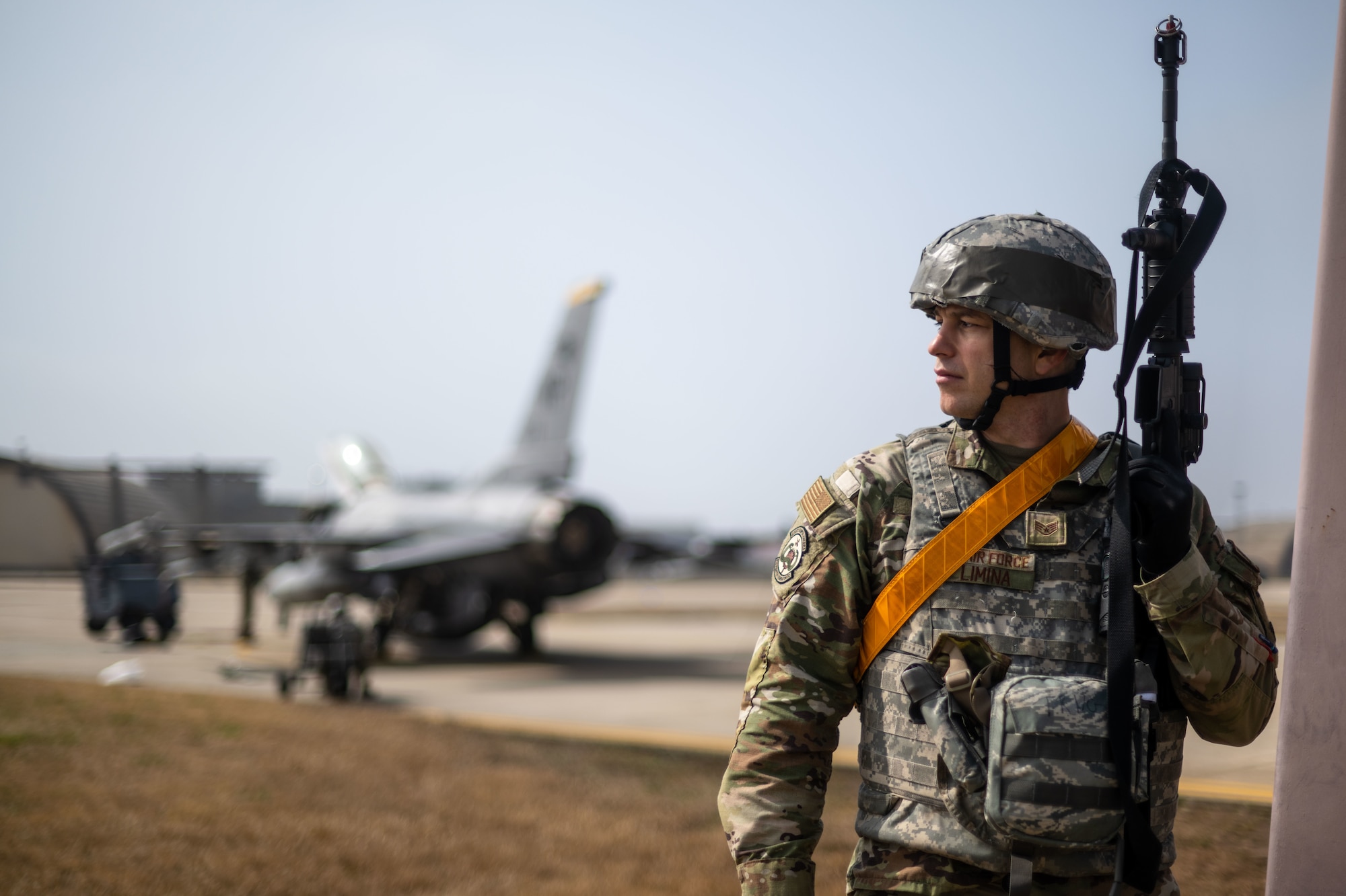 Staff Sgt. Chris Limina guards an F-16 Fighting Falcon through ongoing maintenance repairs.