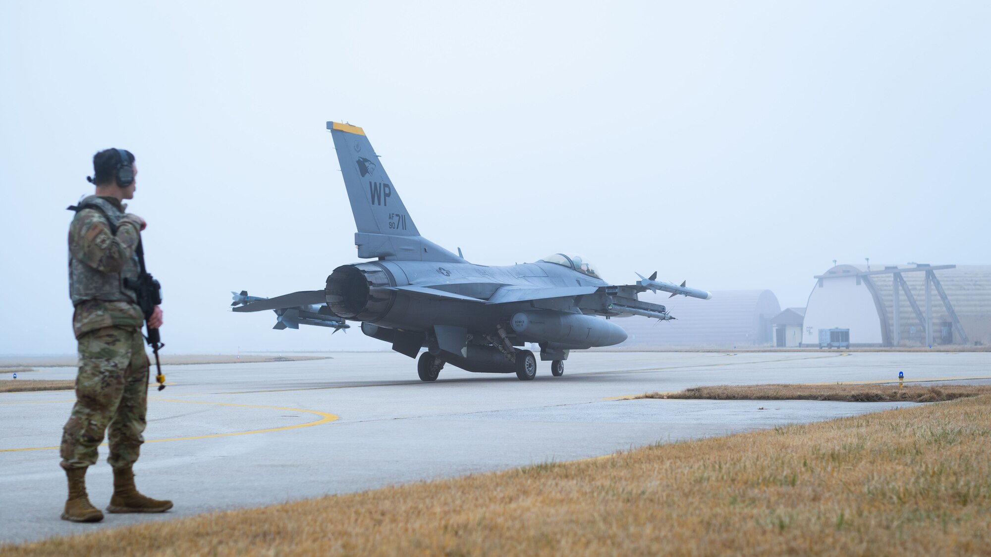 Staff Sgt. Justin Aaron conducts armed guard surveillance during an F-16 Fighting Falcon launch.