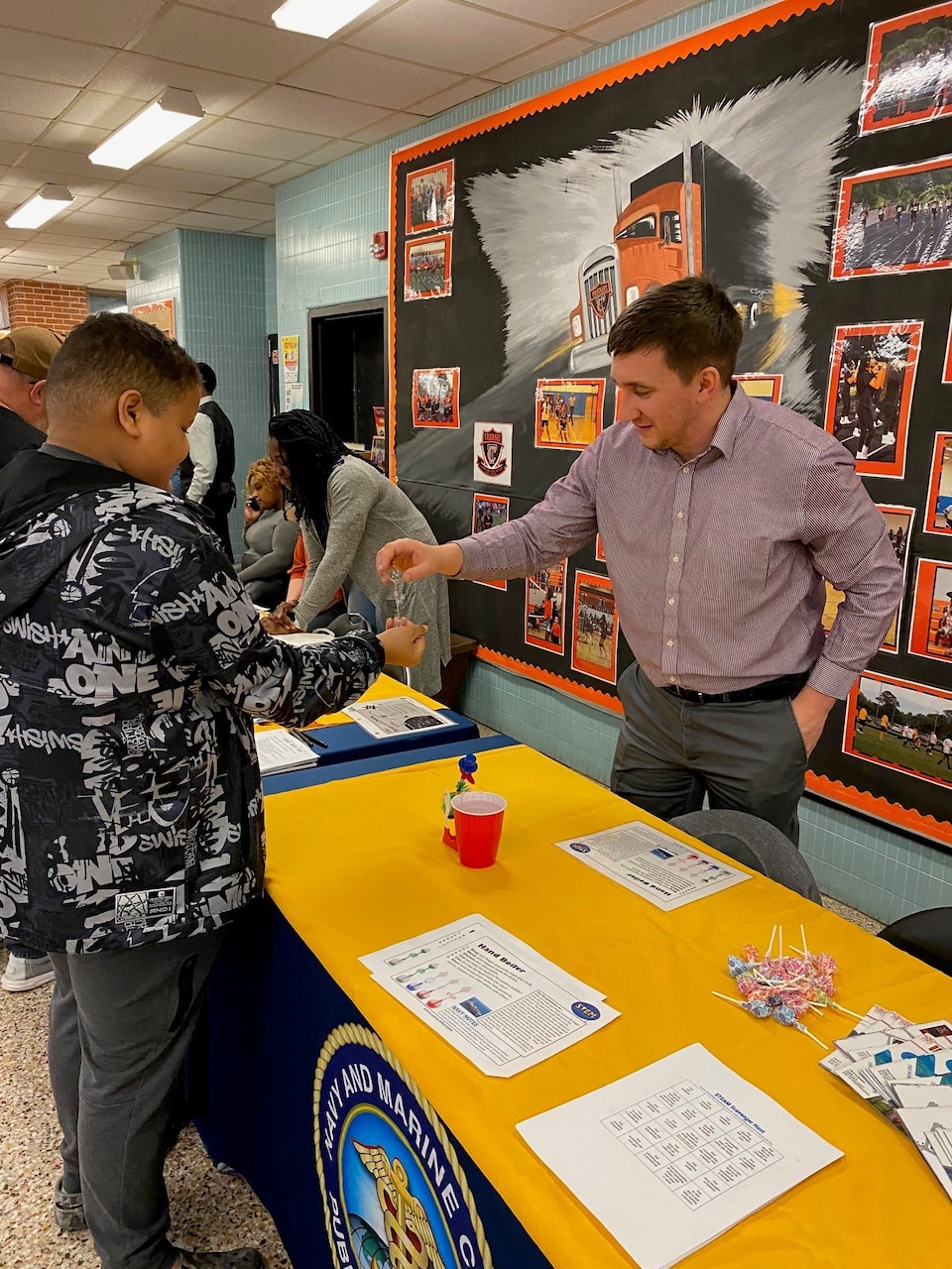 At the Portsmouth Middle School STEAM EXPO, which took place March 26, 2024, Navy and Marine Corps Force Health Protection Command (NMCFHPC) STEM Team volunteers helped extend STEAM disciplines: Science, Technology, Engineering, Art, and Math, beyond the classroom, engaging students with interactive demonstrations. Epidemiologist Nicholas Seliga demonstrated hand boilers, engaging students with principles of temperature and pressure as they witnessed the liquid respond to their touch.