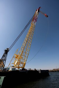 A large crane barge sits in a body of water.