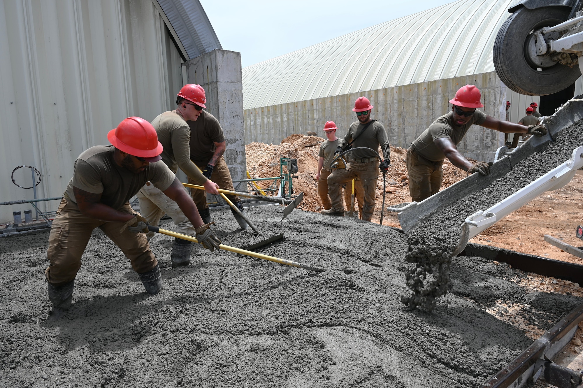 Several Airmen spread concrete mixture on the perimeter of the elevation.