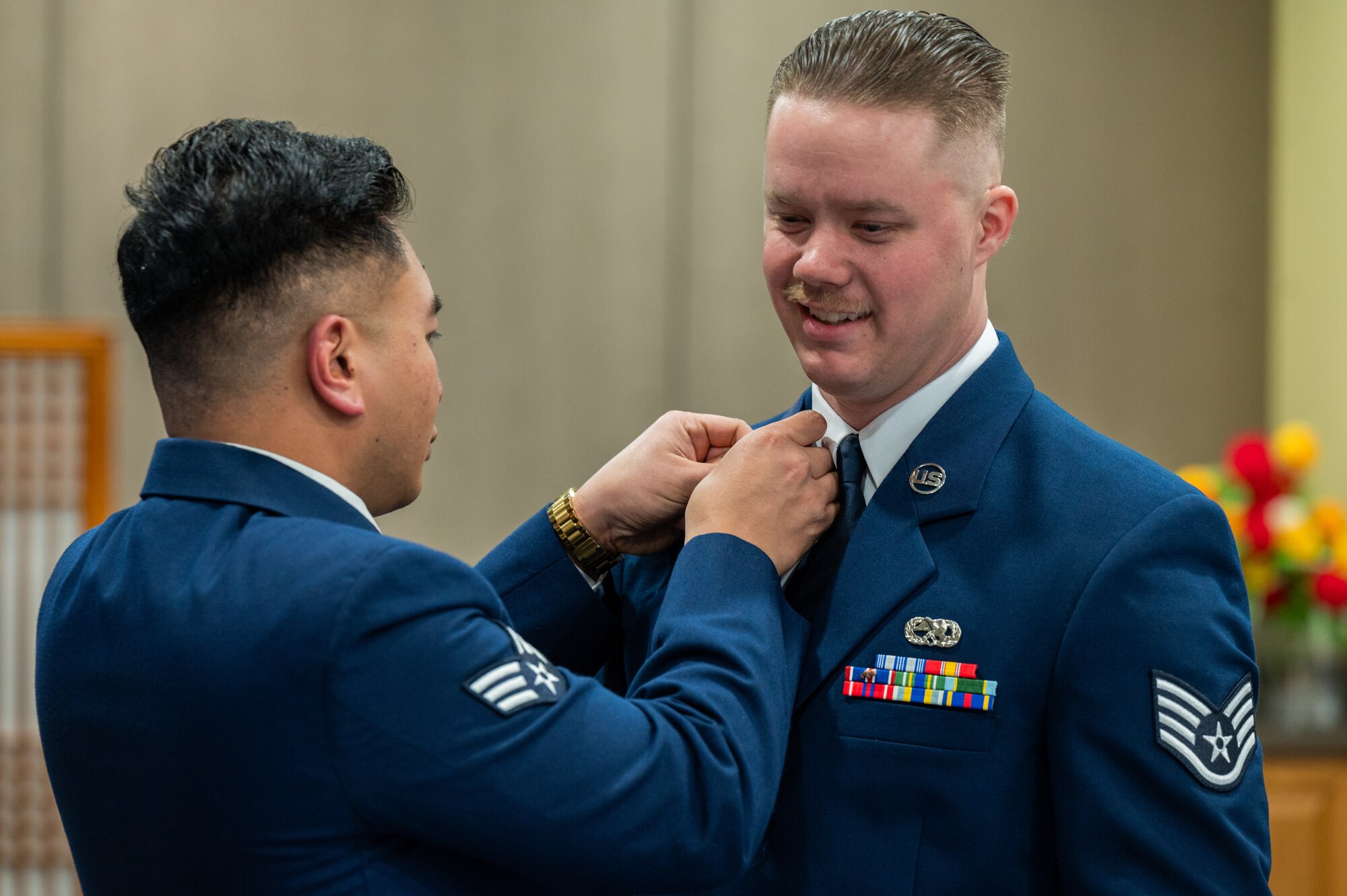 U.S. Air Force Senior Airman Sovann Din, left, and Staff Sgt. Daniel Lober, 36th Fighter Generation Squadron dedicated crew chiefs, adjust uniforms before Airman Leadership School class 24-B graduation ceremony at Osan Air Base, Republic of Korea, March 21, 2024. ALS is a five week-long course where Airmen are trained on tactics for effective leadership. (U.S. Air Force photo by Airman 1st Class Chase Verzaal)